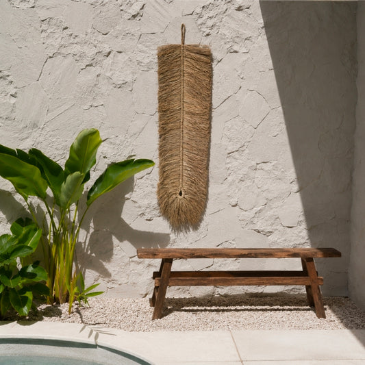Lange raffia wandhanger 110 cm aan witte structuurmuur