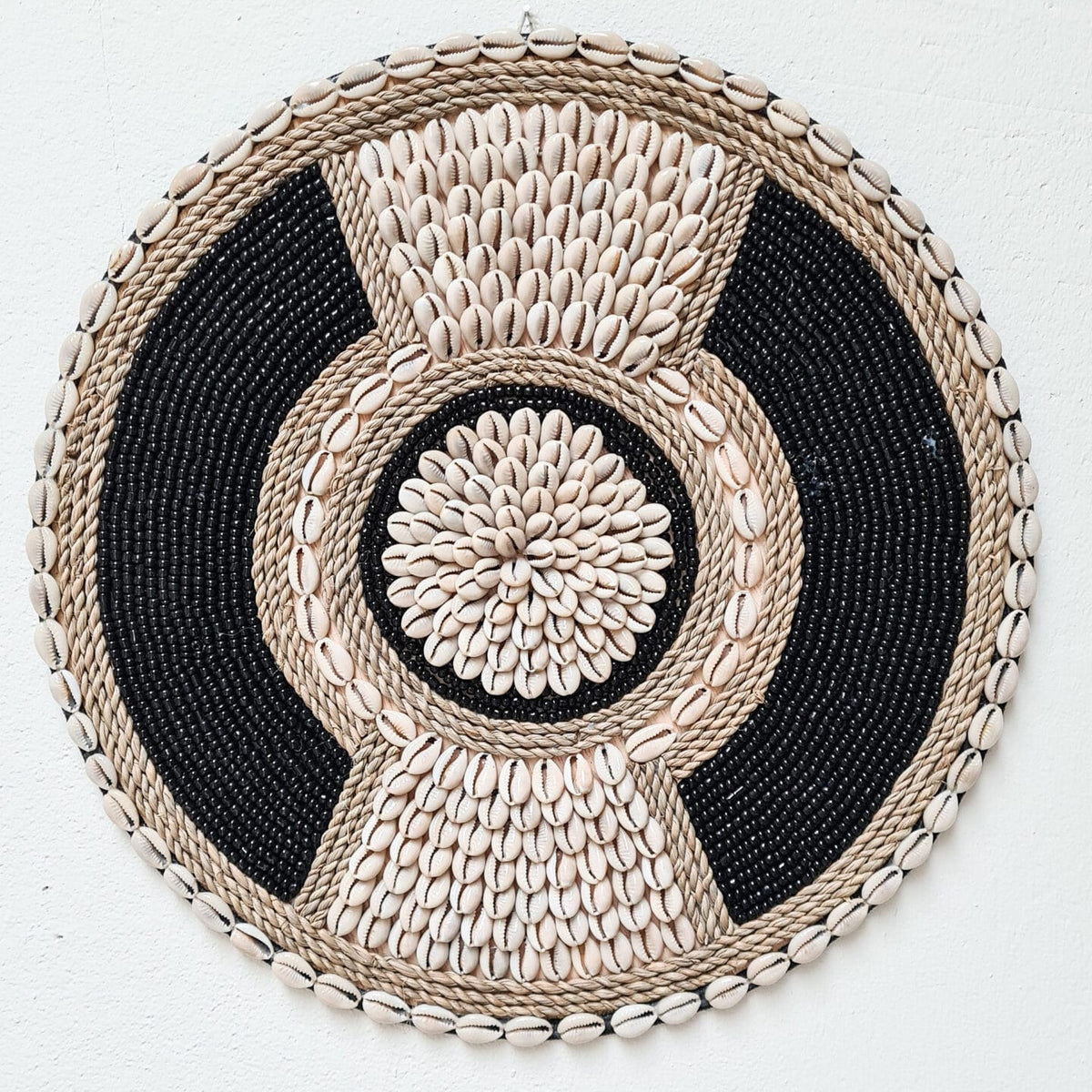 zwart met beige wanddecoratie van schelpen en kralen in boho stijl