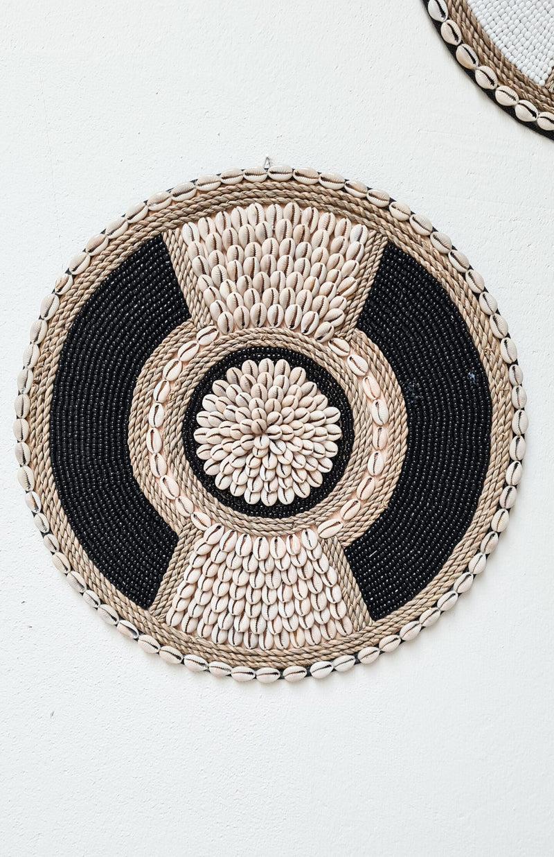 zwart met beige wanddecoratie van schelpen en kralen in boho stijl