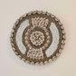 Ronde wanddecoratie van kralen en schelpen in de kleuren wit en beige.