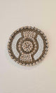 Ronde wanddecoratie van kralen en schelpen in de kleuren wit en beige.