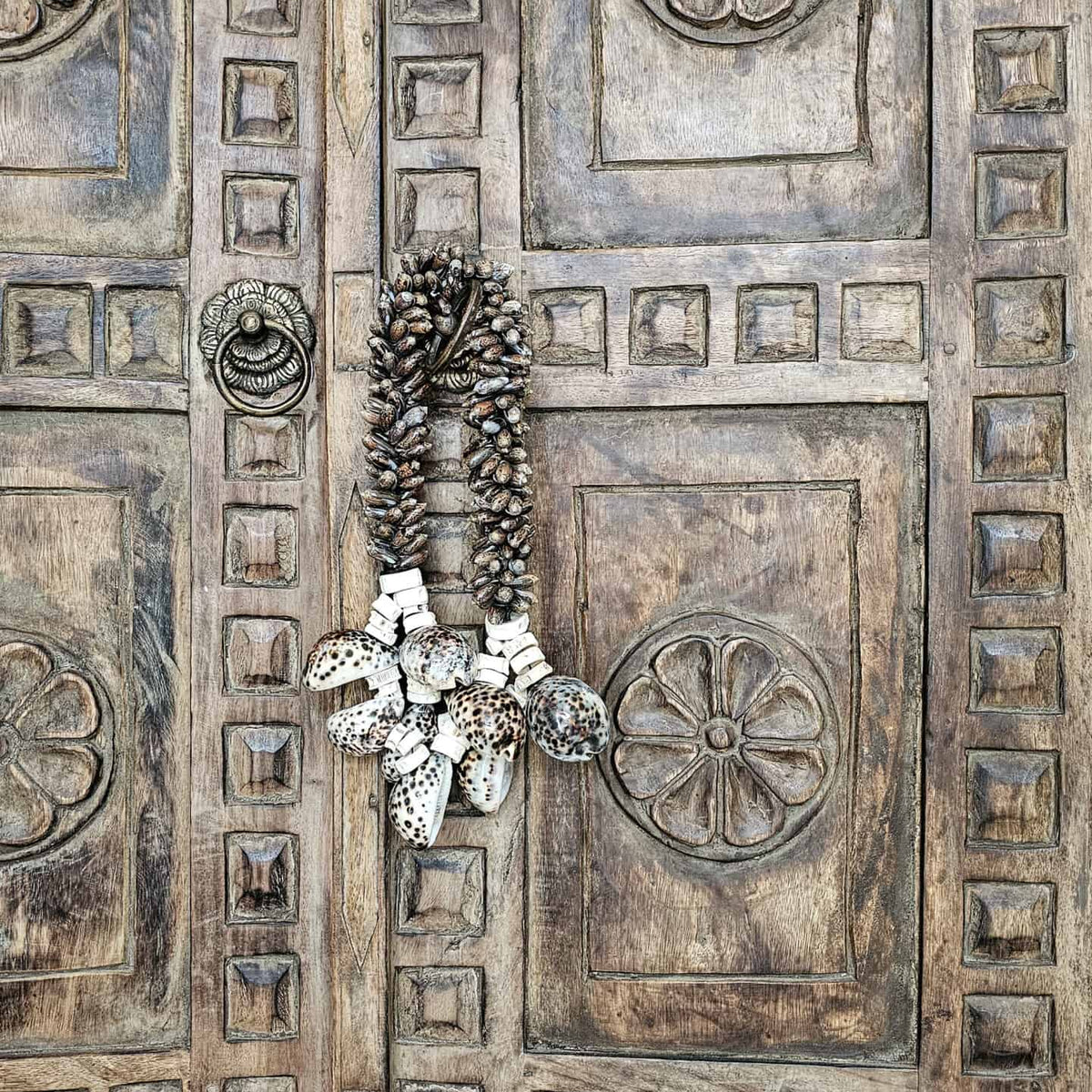boho schelpenketting hangt aan Balinese deur