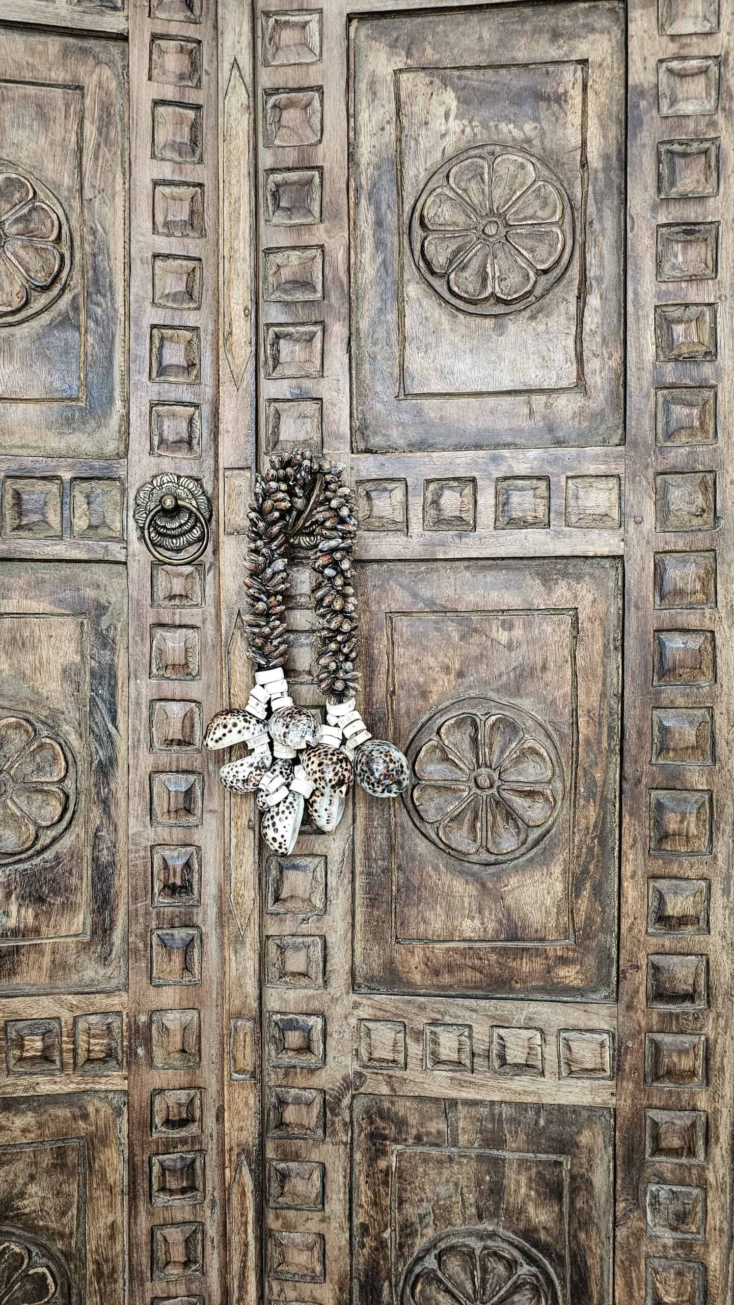 boho schelpenketting hangt aan Balinese deur