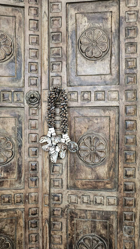 boho schelpenketting hangt aan Balinese deur