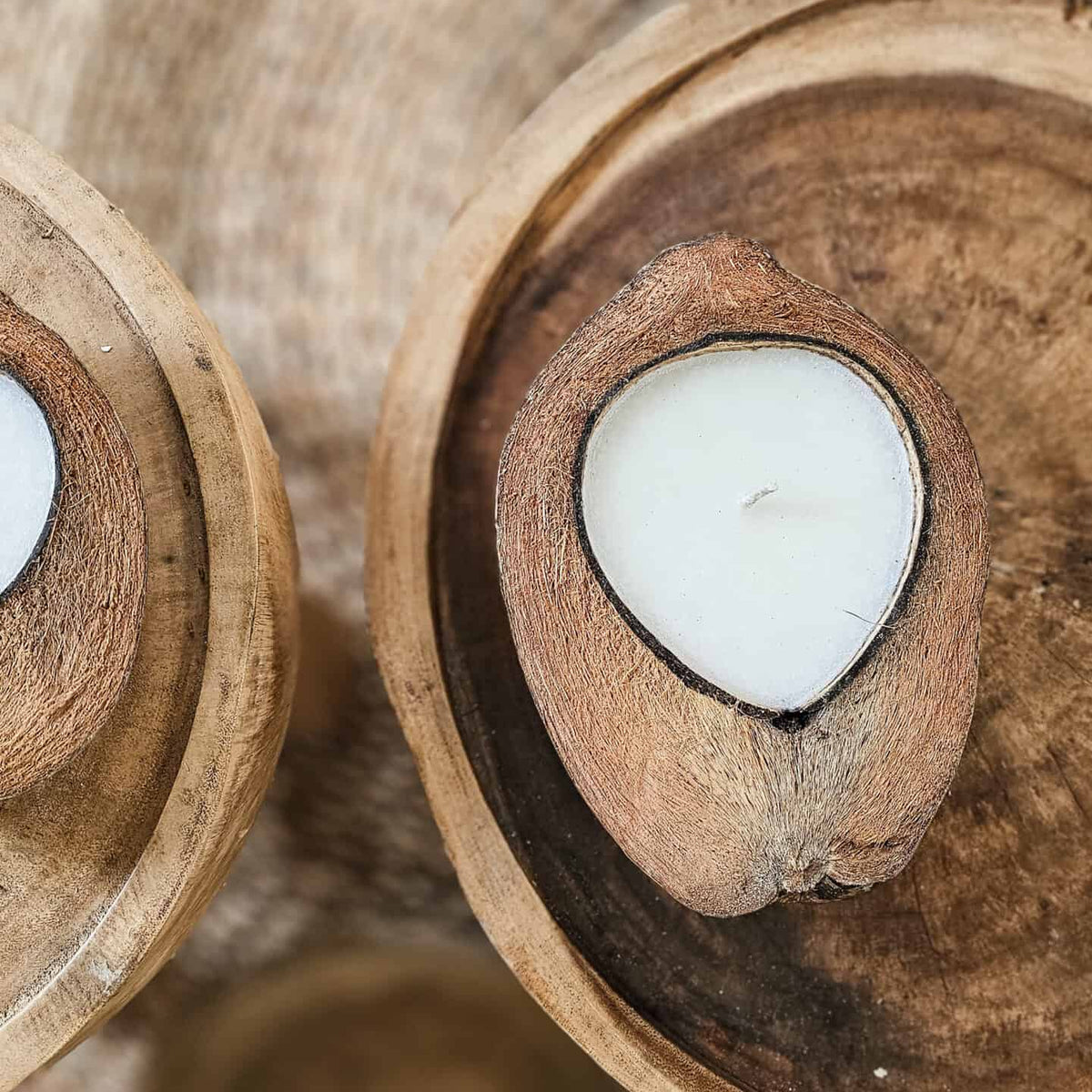 natuurlijke kaarsen in kokosnoot op houten salontafel