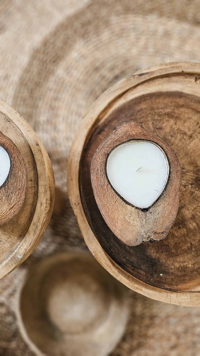 natuurlijke kaarsen in kokosnoot op houten salontafel