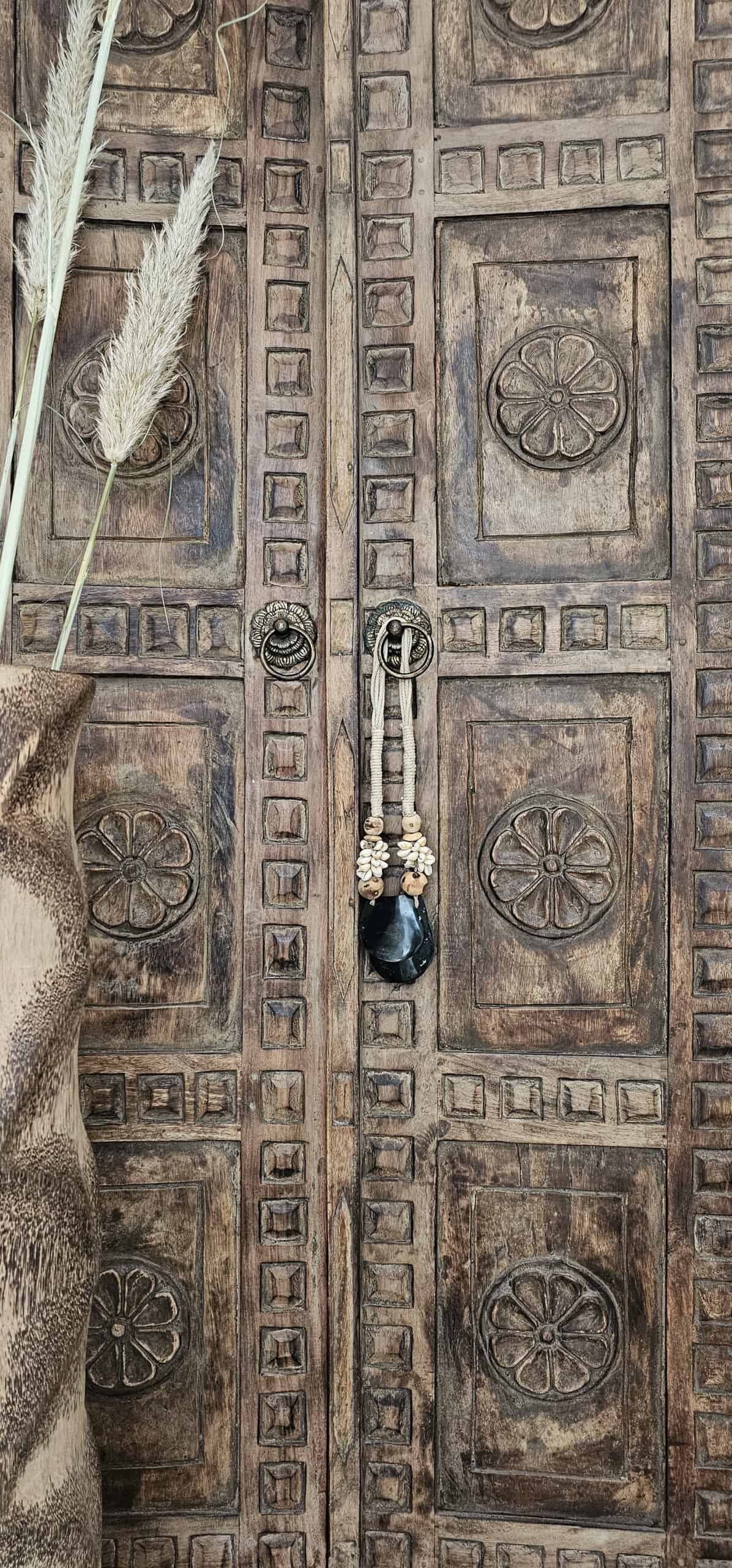 Woonketting met schelpen hangt aan Balinese deur