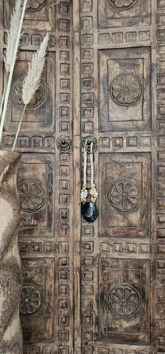 Woonketting met schelpen hangt aan Balinese deur