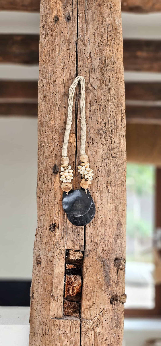 Schelpenketting uit Bali hangt aan hout