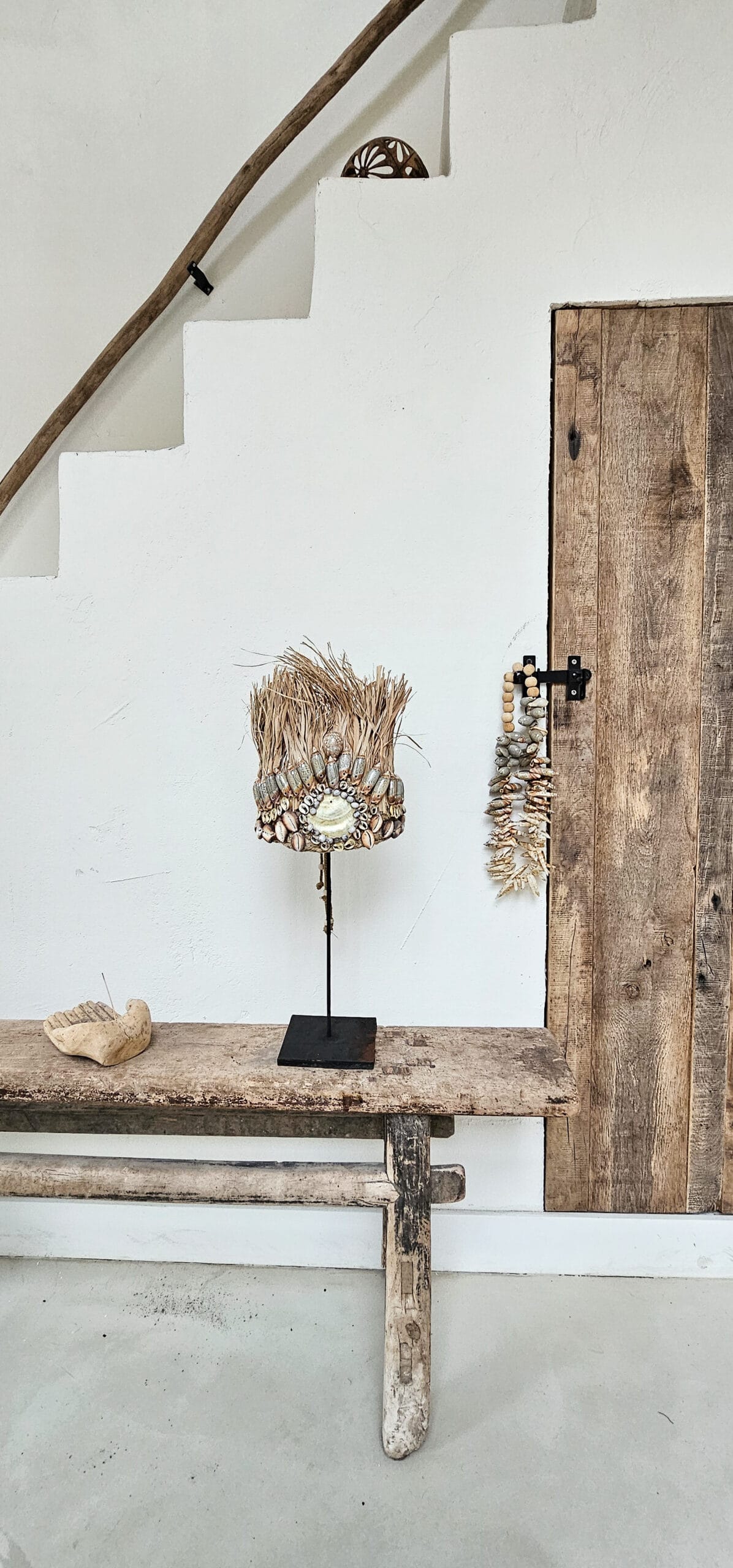 Balinese schelpentooi van raffia en schelpen op standaard