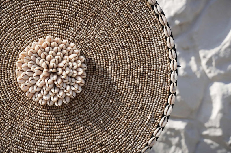 Details van schaal met kralen en schelpen in de kleuren wit en beige