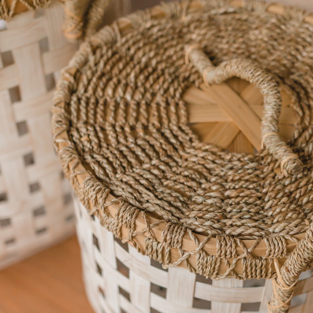 handgemaakte wasmand met deksel van bamboe, zeegras en rotan in de kleuren wit en naturel.