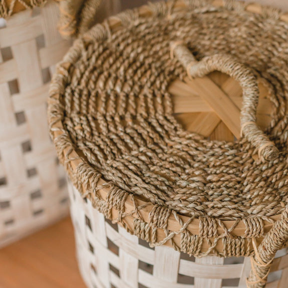 handgemaakte wasmand met deksel van bamboe, zeegras en rotan in de kleuren wit en naturel.