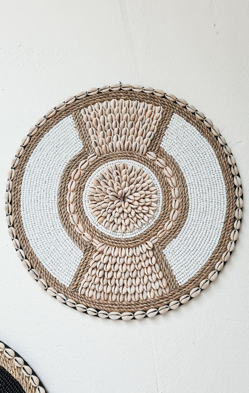 ronde boho wanddecoratie in de kleuren beige en wit van kralen en schelpen