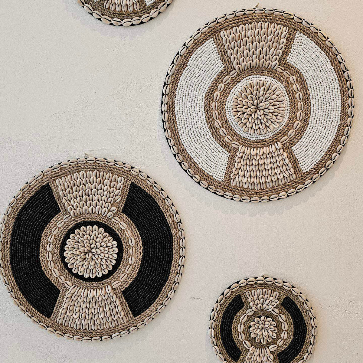 ronde boho wanddecoratie in de kleuren beige en wit van kralen en schelpen