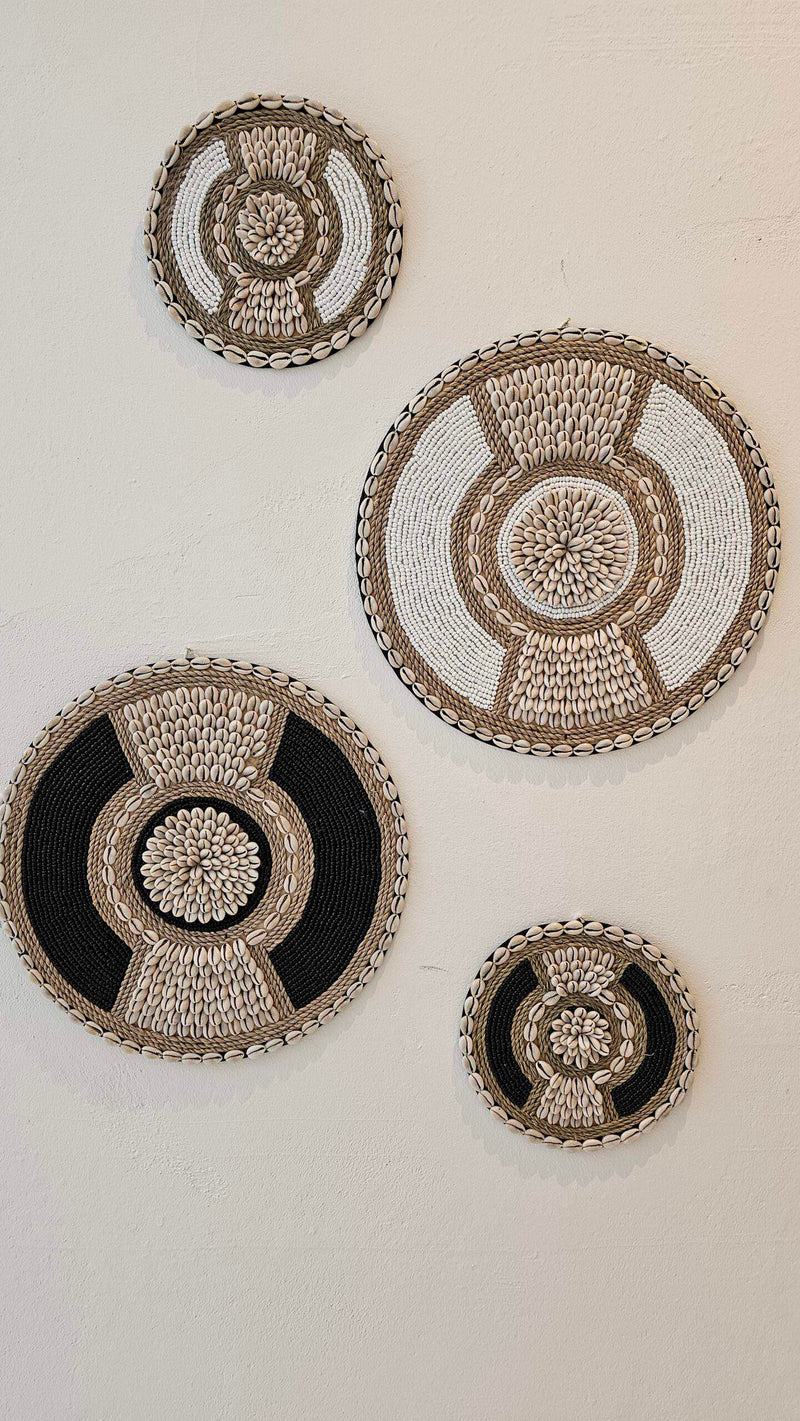 ronde boho wanddecoratie in de kleuren beige en wit van kralen en schelpen