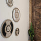 ronde boho wanddecoratie in de kleuren beige en wit van kralen en schelpen