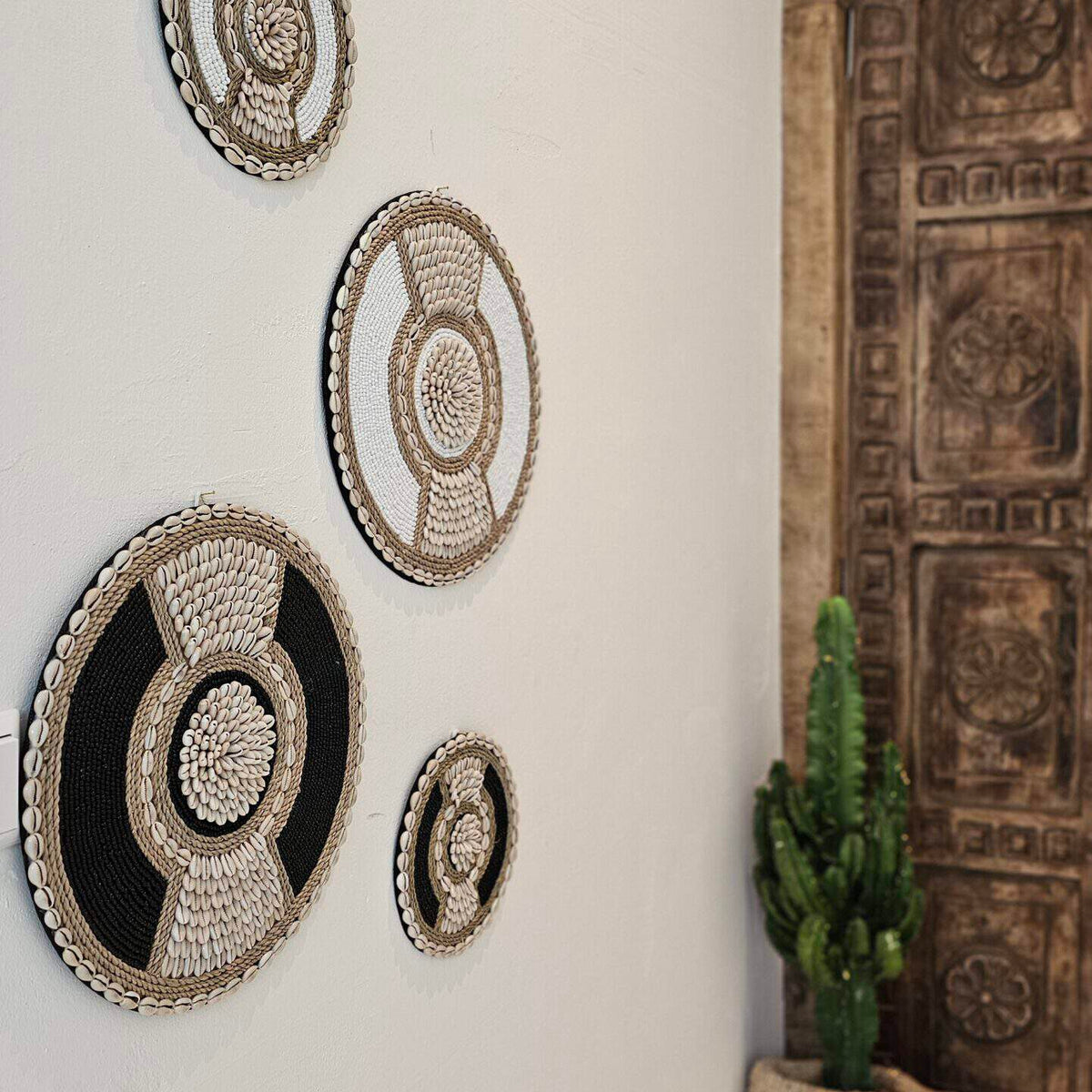 zwart met beige muurdecoratie van schelpen en kralen in boho stijl