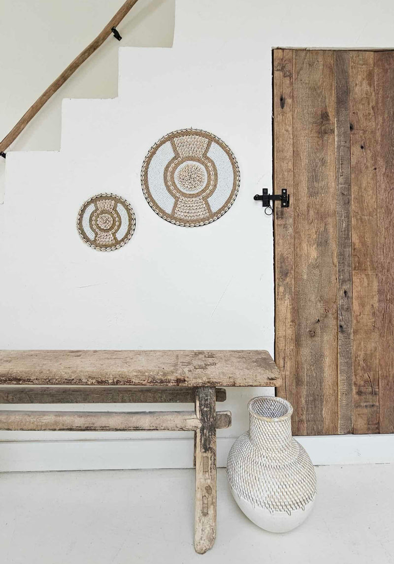 ronde boho wanddecoratie in de kleuren beige en wit van kralen en schelpen